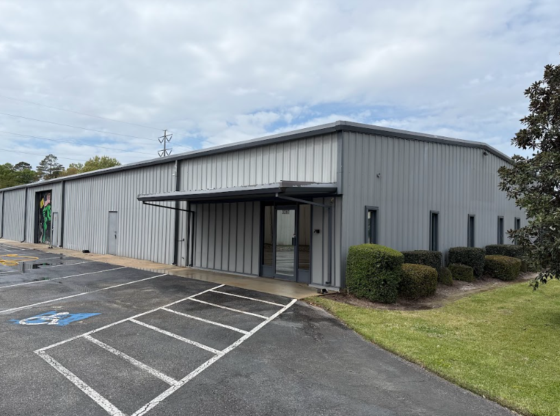 Commercial metal building with freshly pressure-washed entry and parking area